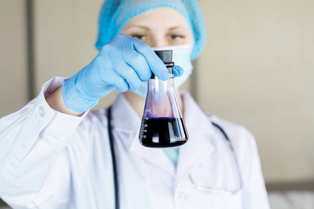 Laboratory scientist examining a chemical solution in a conical flask
