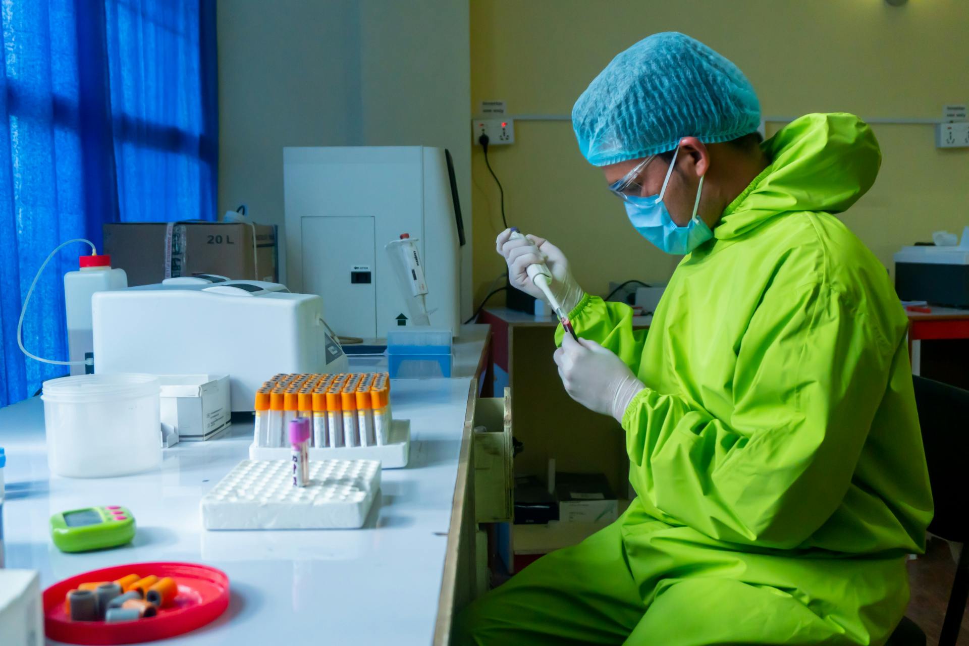 Scientist in protective clothing preparing laboratory samples