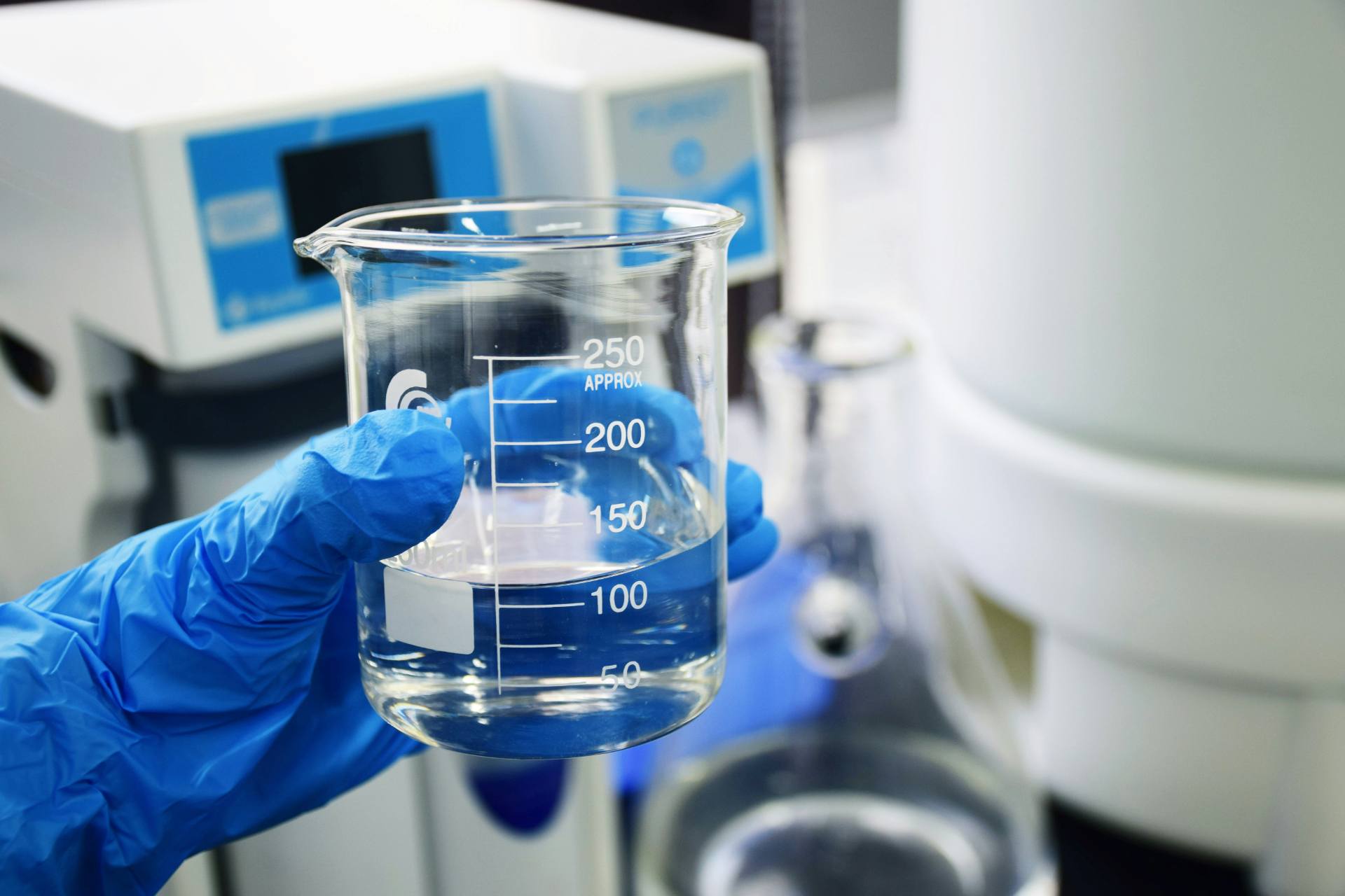 Gloved hand holding a chemical sample vial